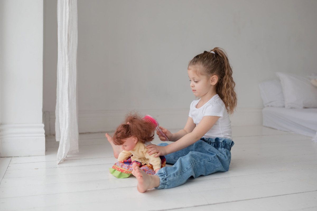 petite fille joue avec poupée