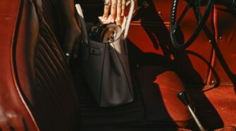 person in black pants sitting on brown leather car seat