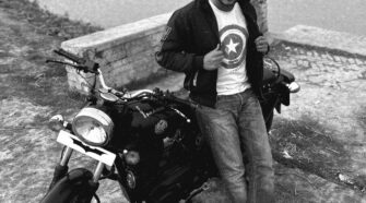 a man sitting on a bench next to a motorcycle